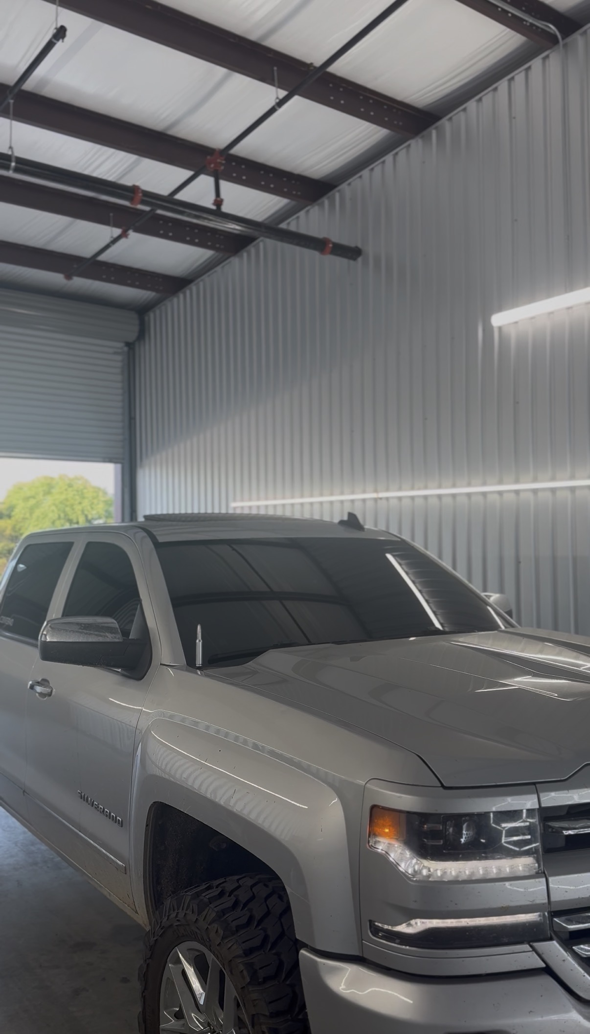 Gray Chevrolet with tinted windows inside the shop