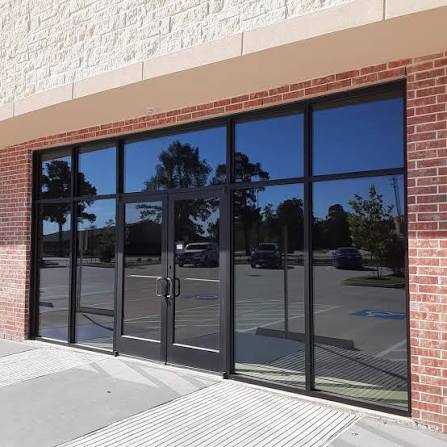 Brick storefront with tinted glass doors and display windows