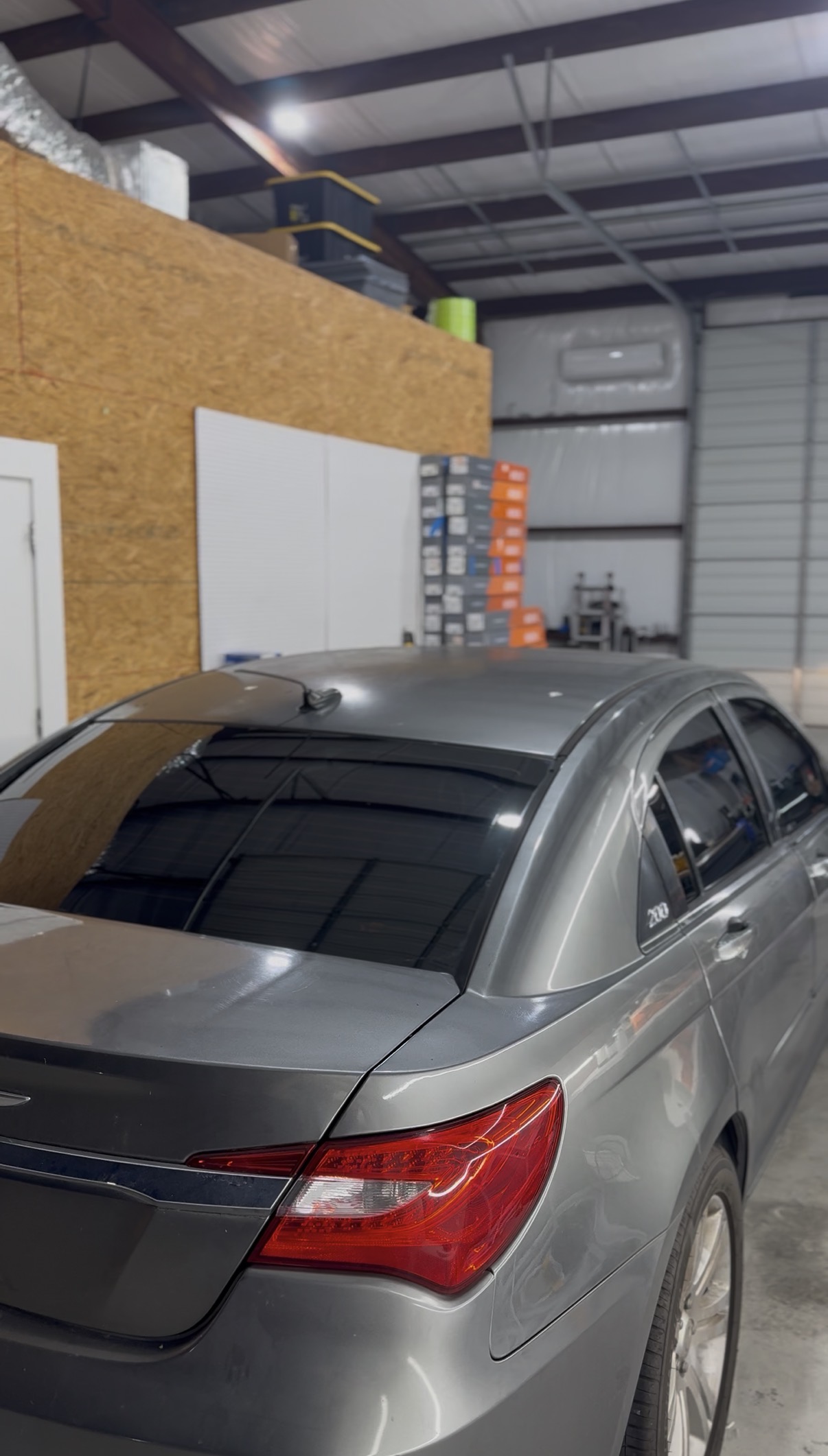 Gray sedan with tinted windows inside the shop