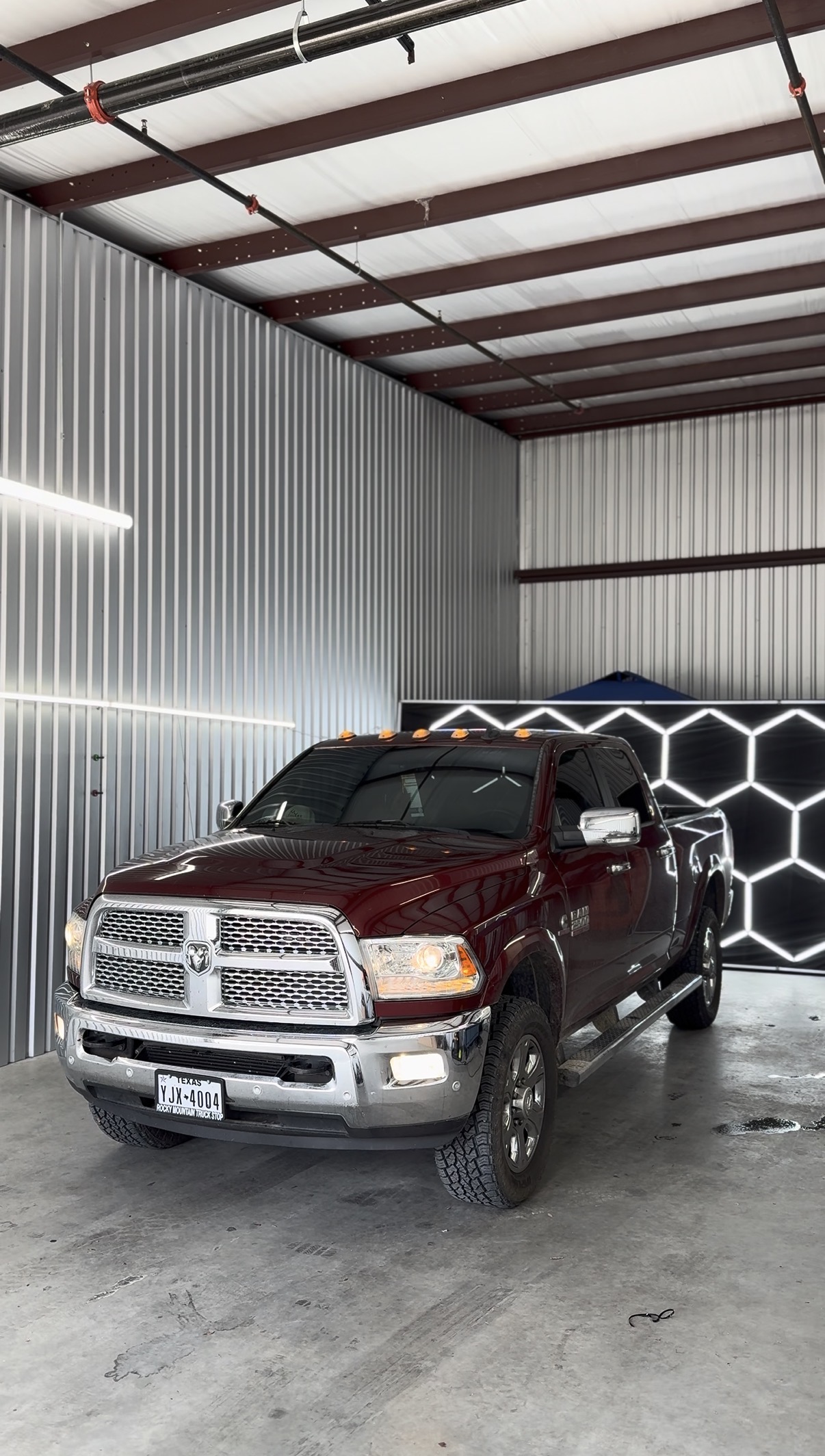 Maroon Ram truck with tinted windows inside the shop