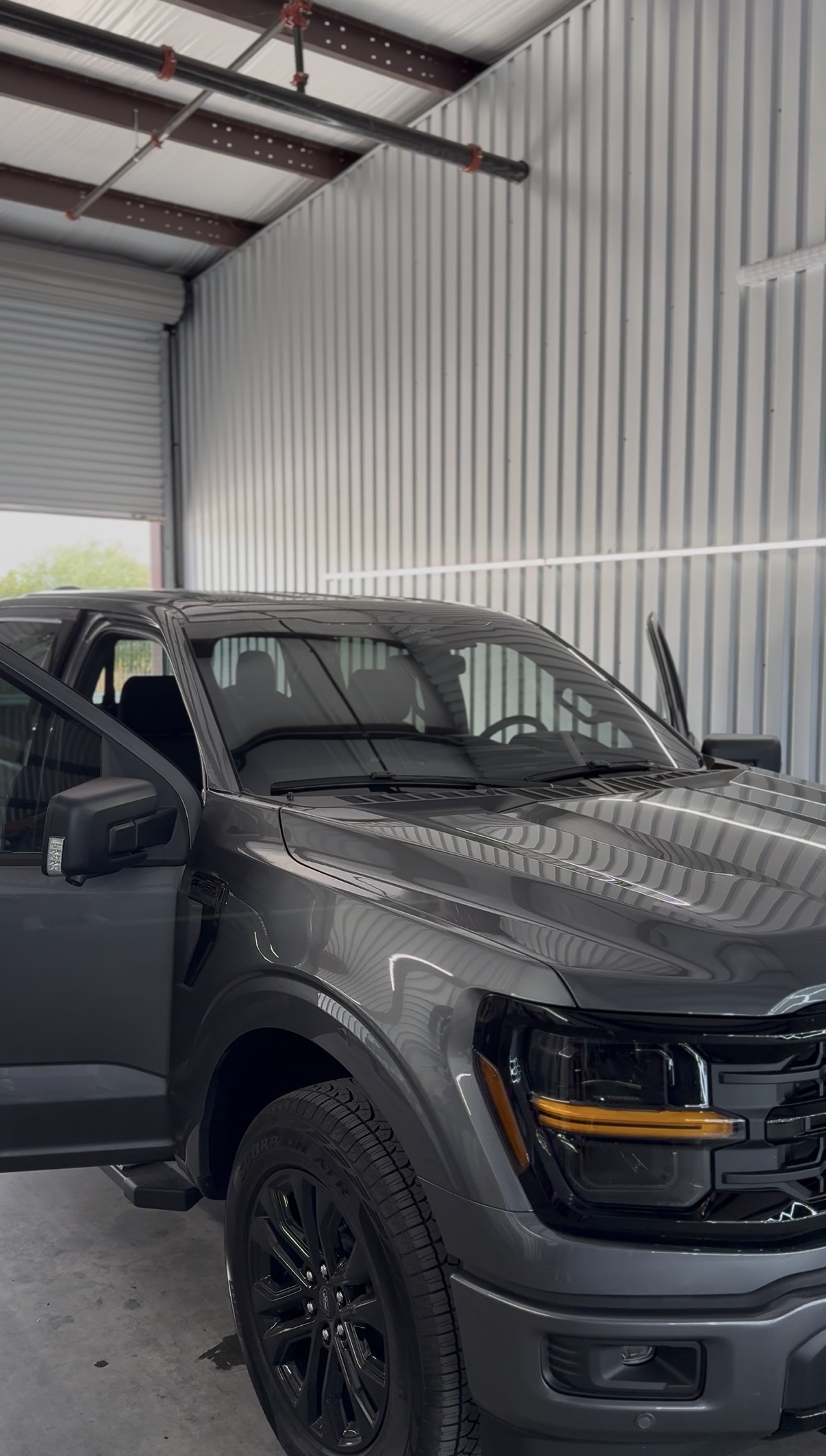 Dark Ford truck with the door open during tint installation