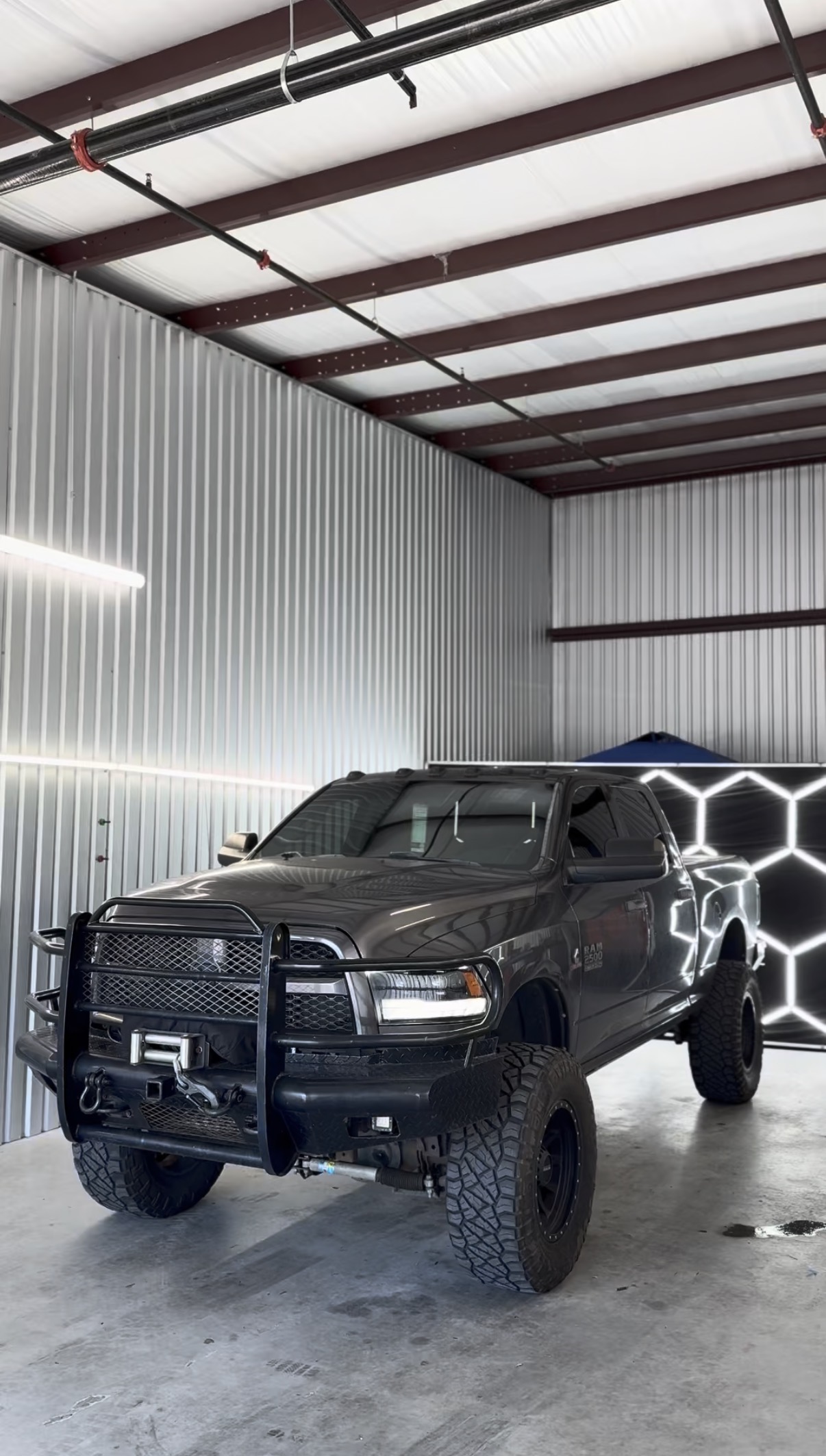 Black lifted Ram truck with tinted windows inside the shop