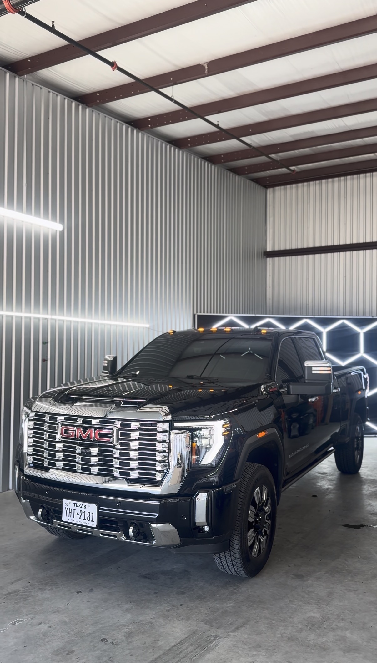 Black GMC Sierra with tinted windows inside the shop