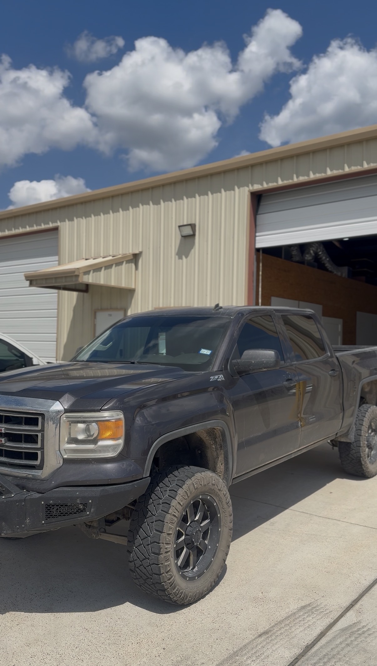 Lifted gray GMC pickup with tinted windows
