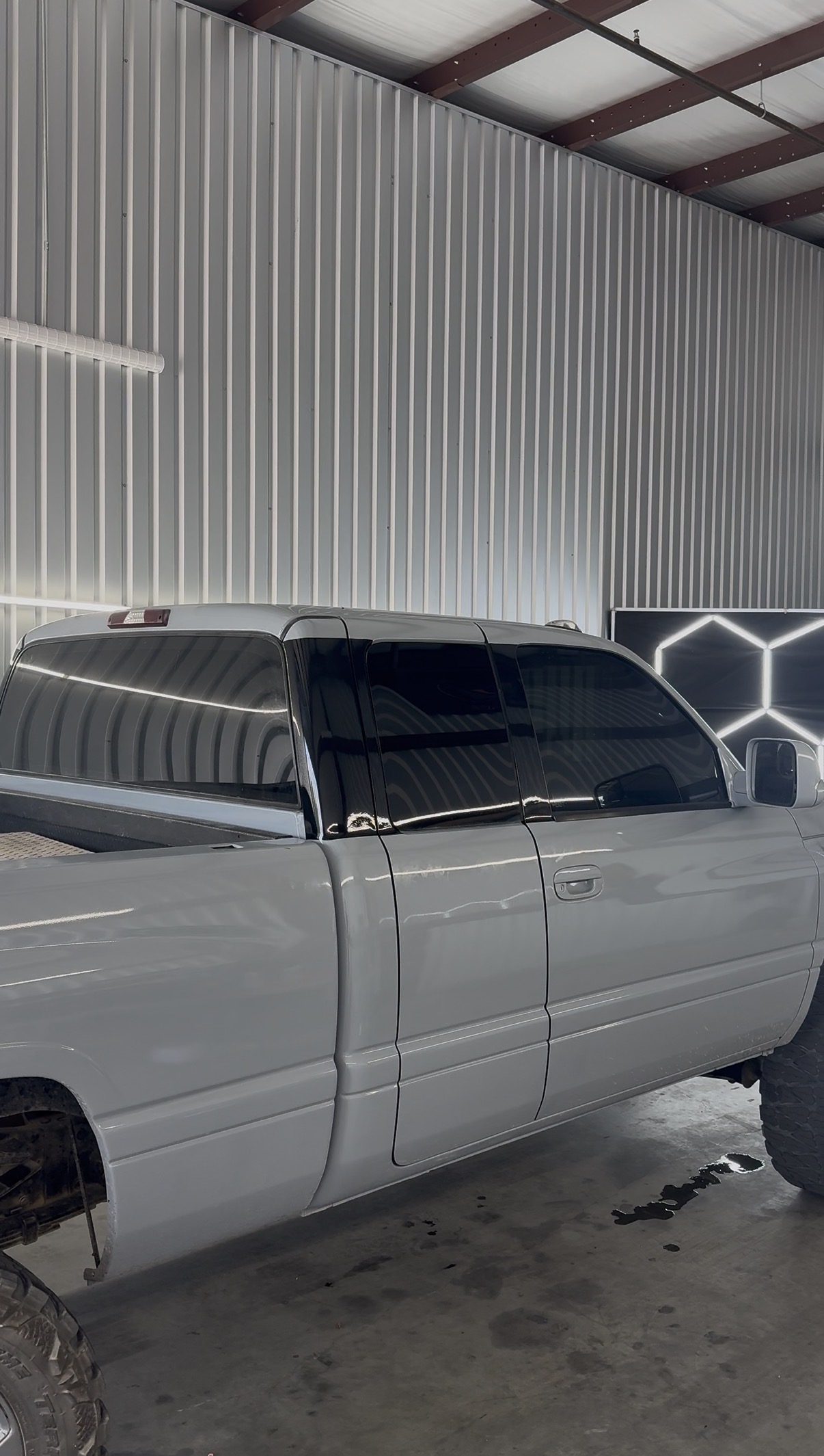 White Chevrolet truck with freshly tinted windows inside the shop