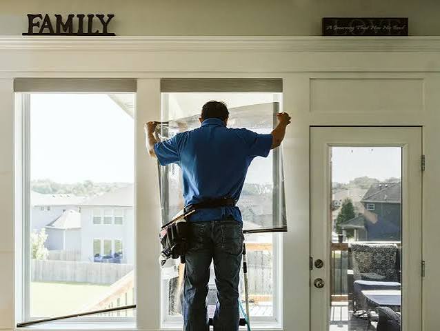 Window film being installed on a home's living room windows