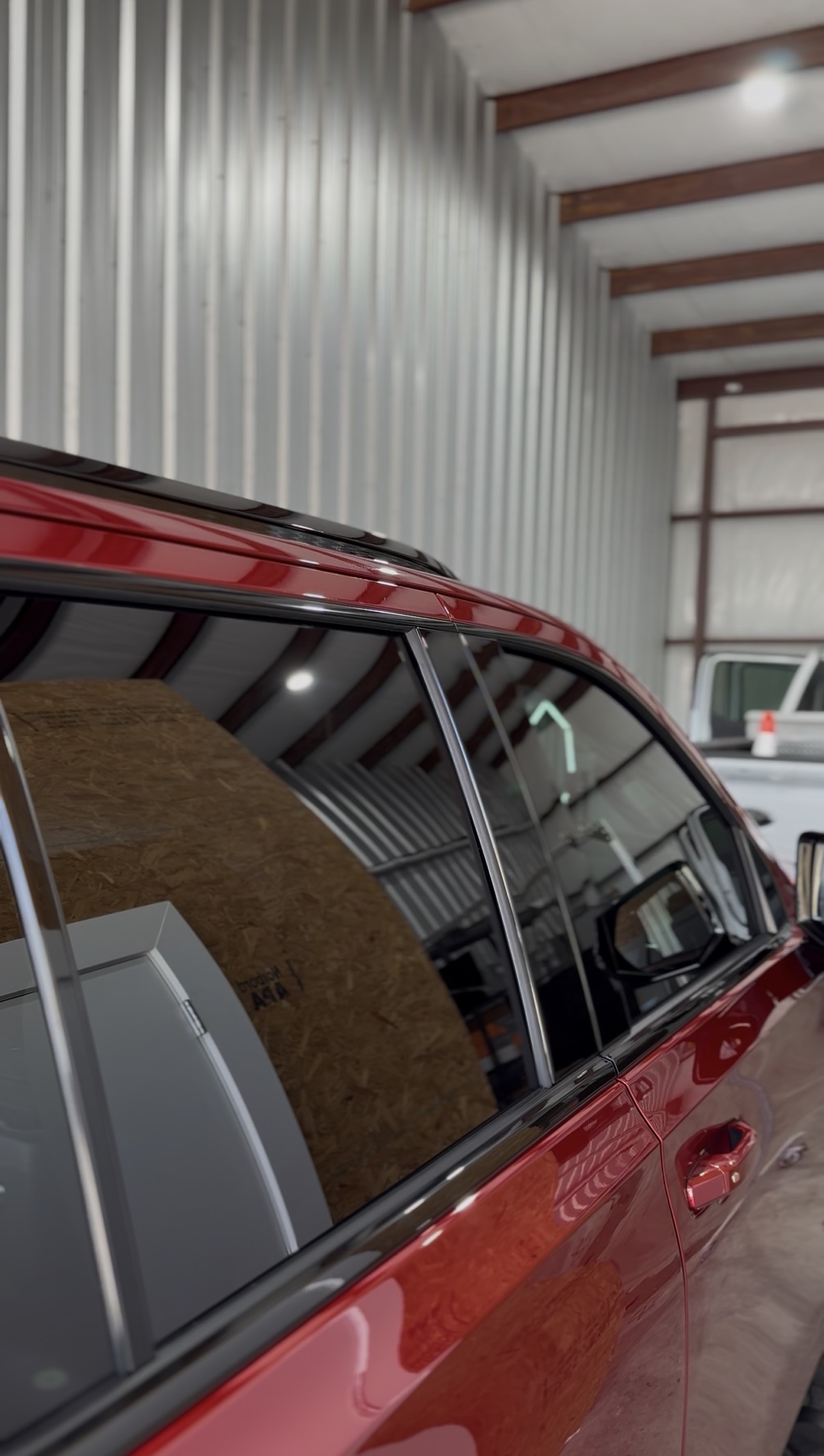 Red car with tinted windows inside the shop