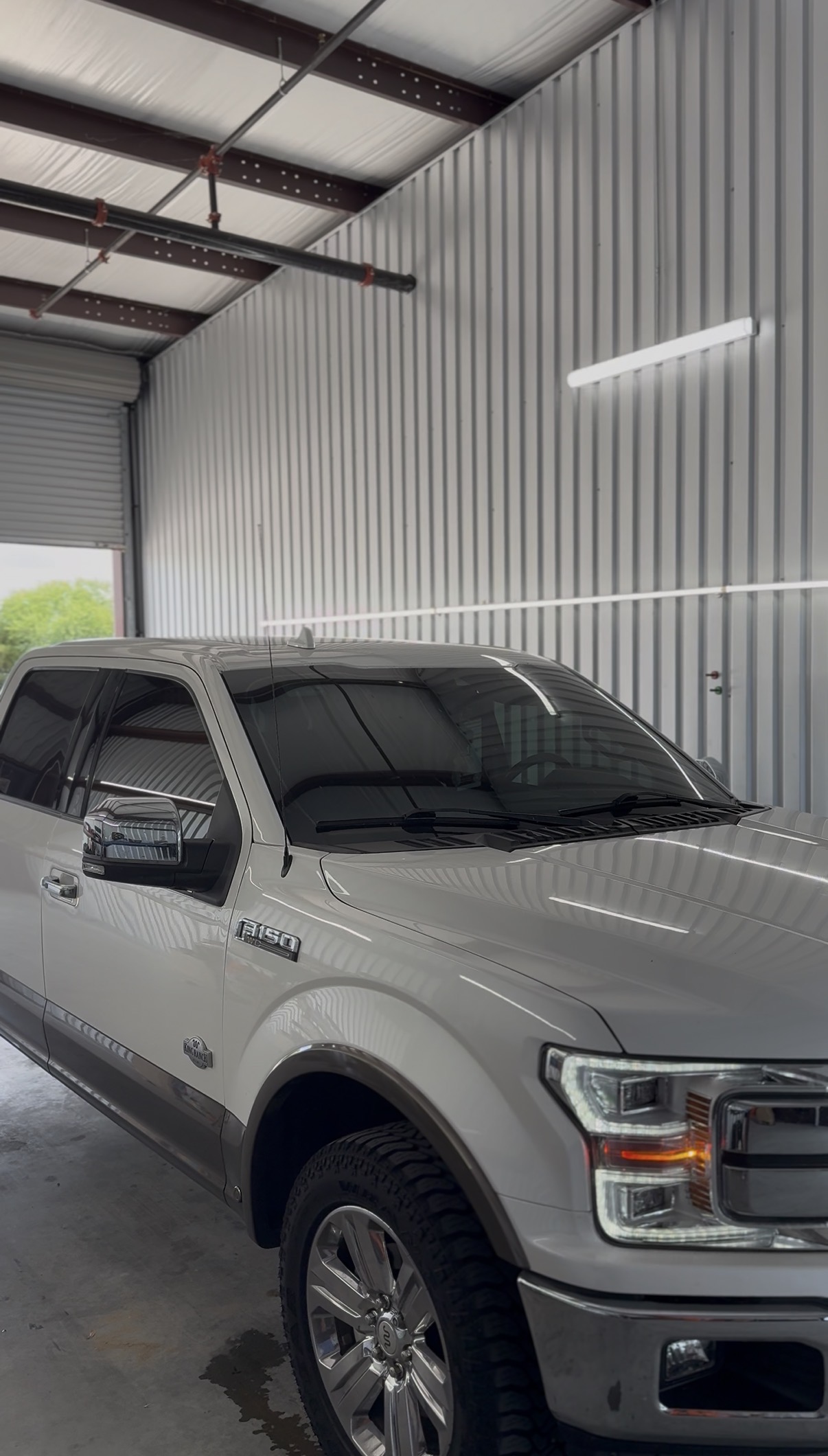 Silver Ford F-150 with tinted windows inside the shop