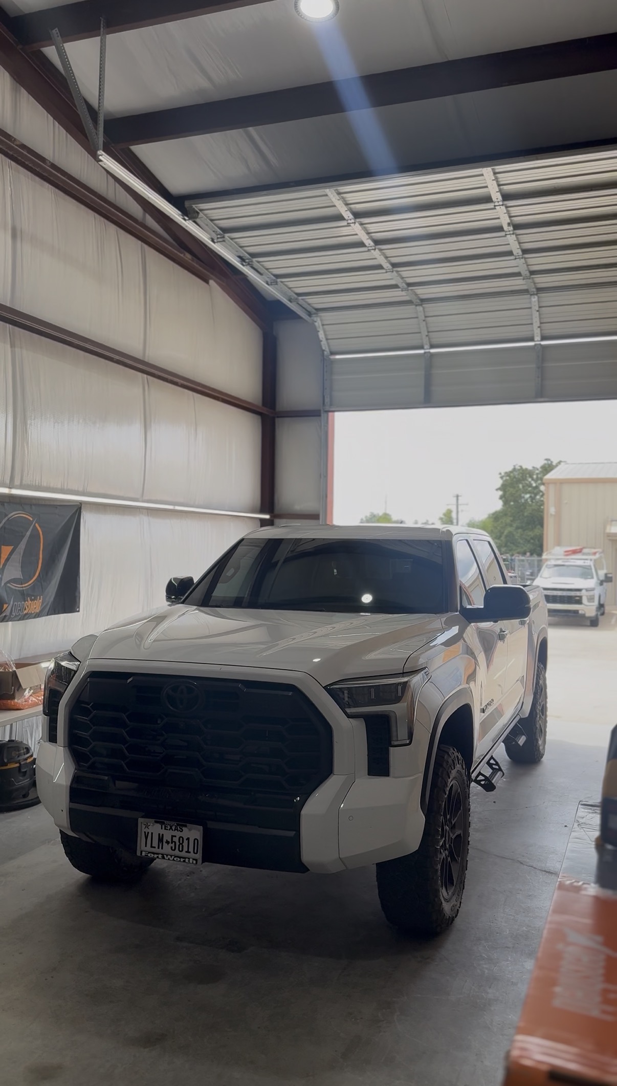 White Toyota Tundra with tinted windows outside the shop