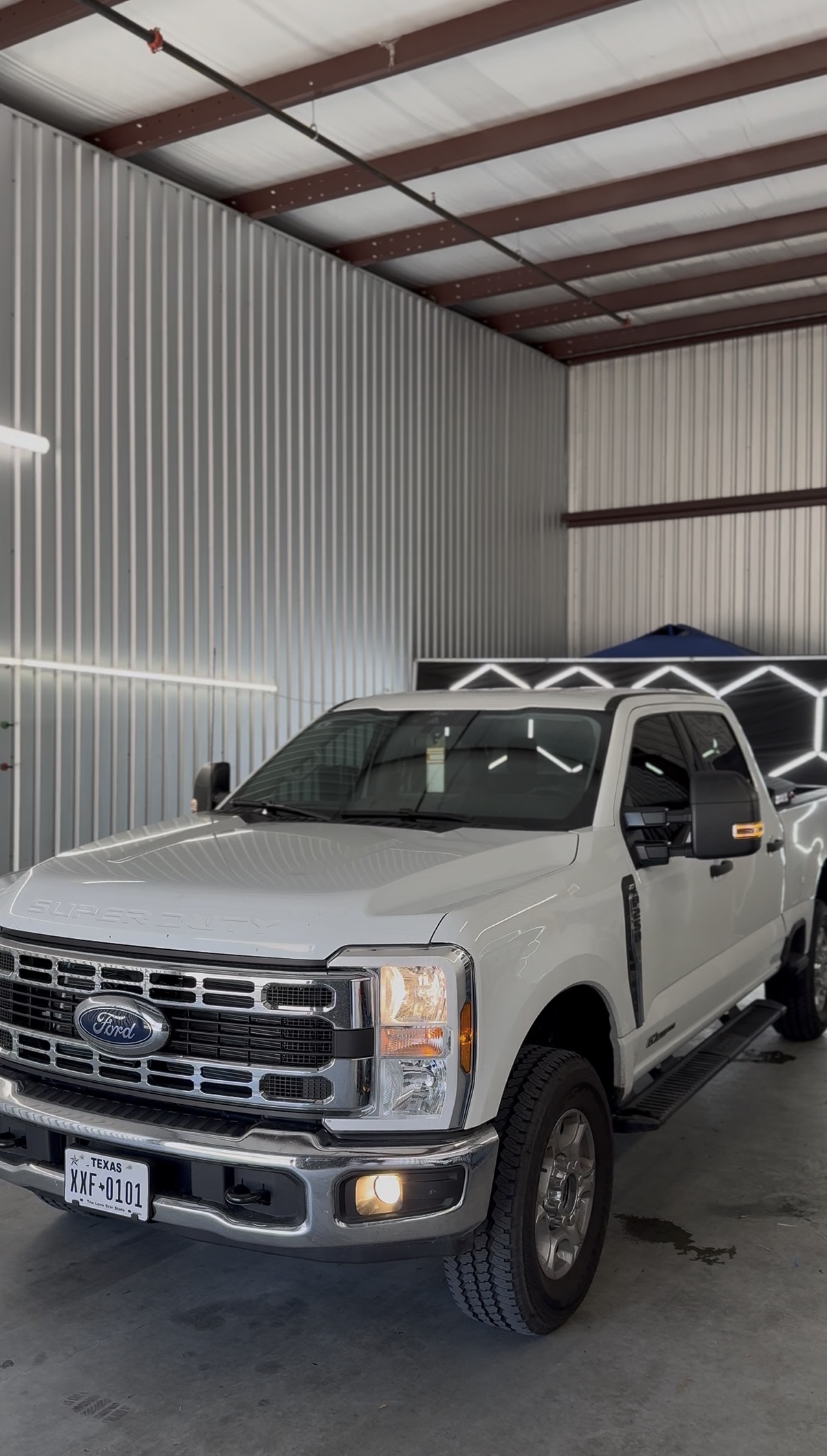 White Ford F-350 with tinted windows inside the shop