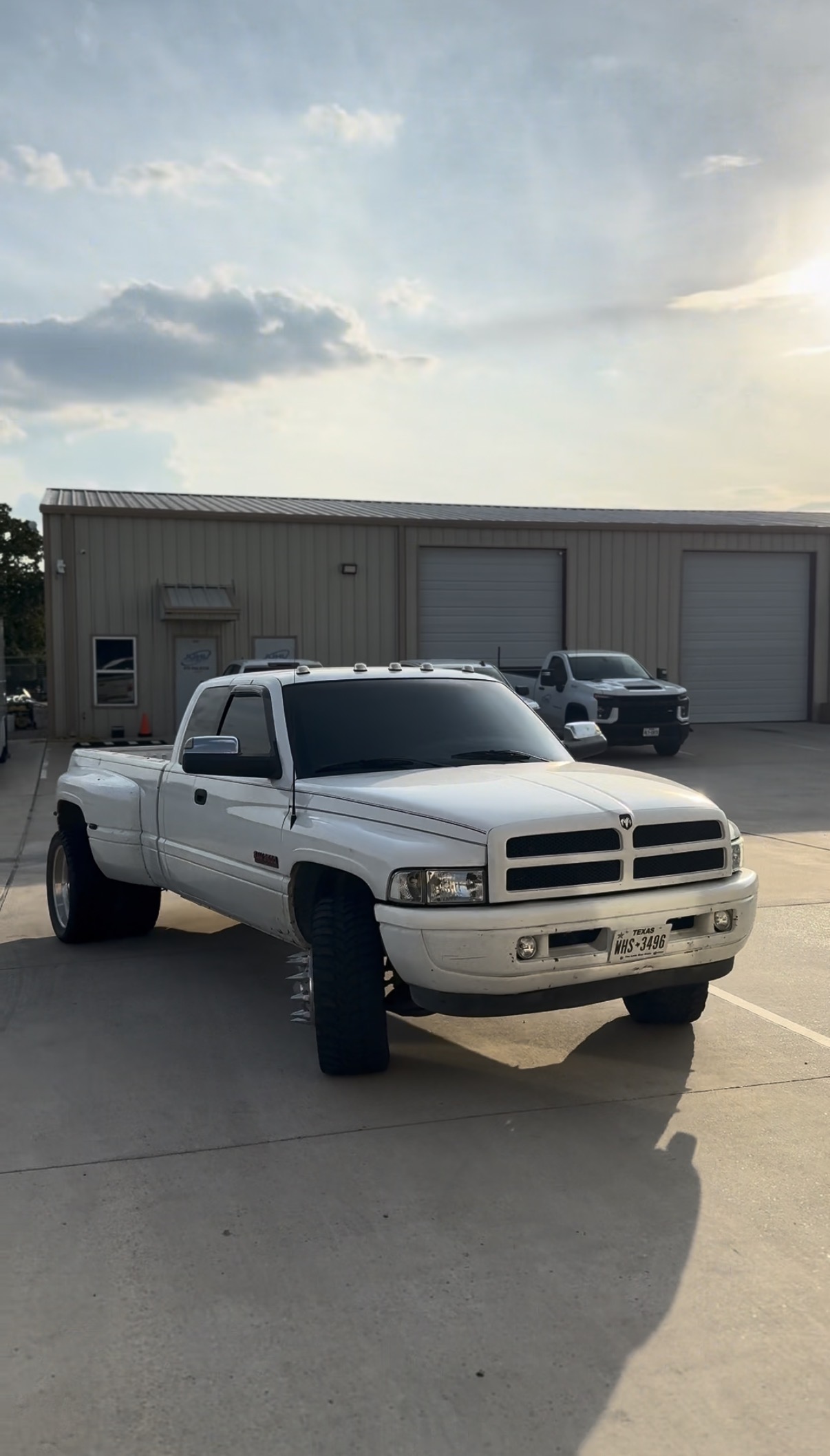 White Ram dually truck with tinted windows outside the shop