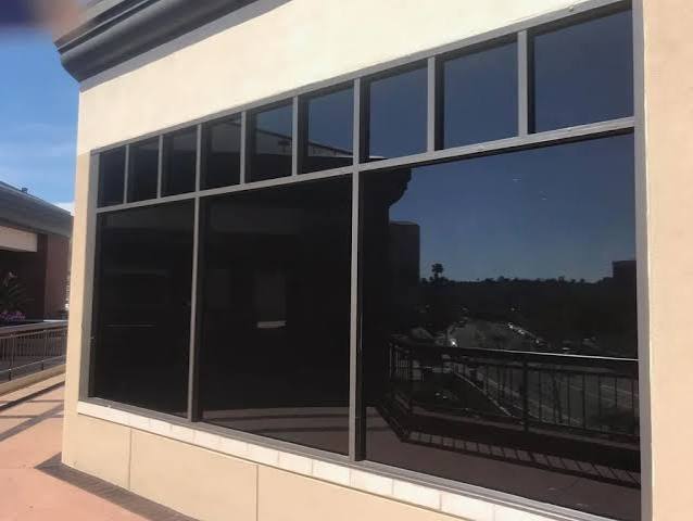 Commercial building with dark tinted windows set in a stucco wall